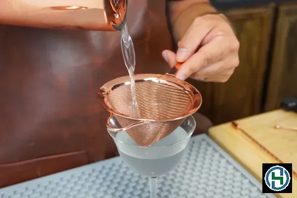 aviation-cocktail-with-5-ounce-fresh-lemon-juice-made-by-a-head-bartender-being-strained-with-a-fine-cocktail-strainer-3 Lọc kỹ dung dịch là bước quan trọng để tránh làm tắc vòi xịt khi sử dụng